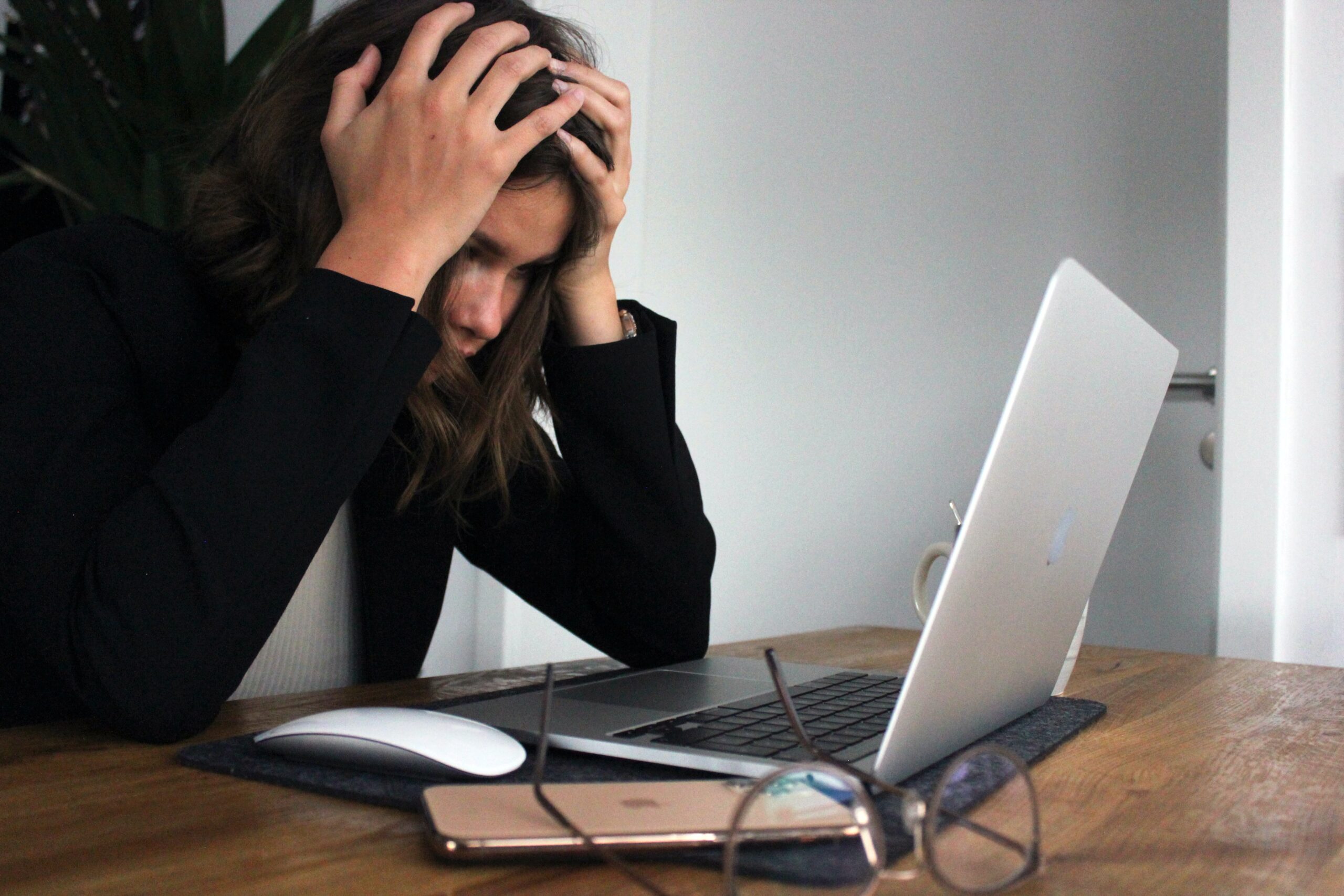 Stressad person framför dator, illustrerar problem att redovisa moms korrekt